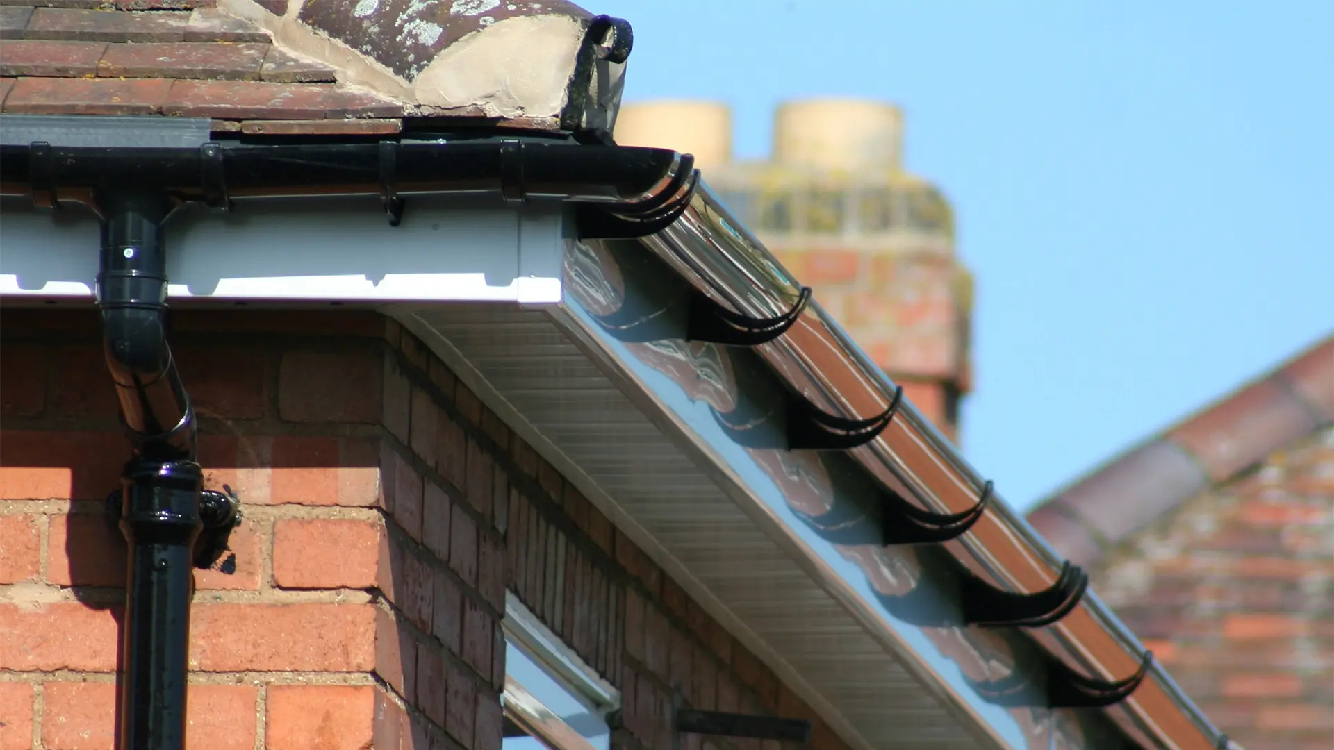 Perfectly clean black gutters and white uPVC fascias on a brick home in Wisbech after professional cleaning services.