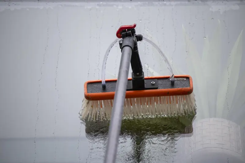 A professional water-fed pole brush cleaning a residential window using pure water technology from Crystal Clean Windows in Parson Drove Wisbech.