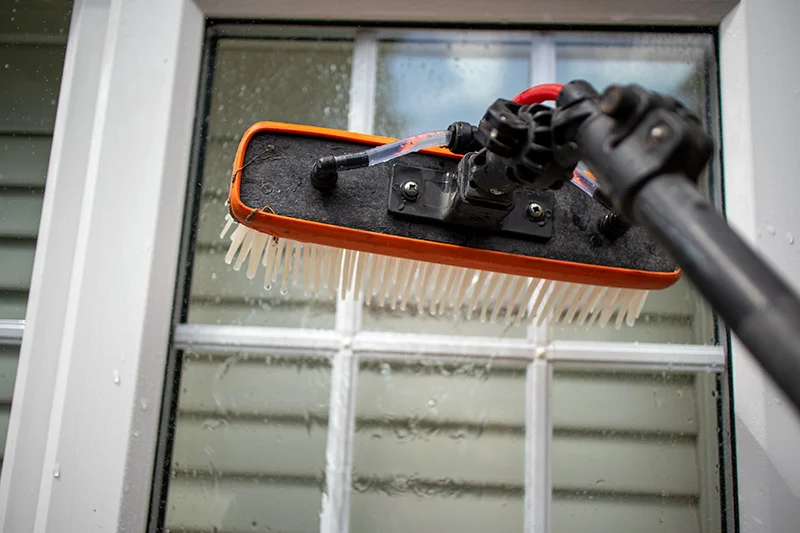 Professional water-fed pole system cleaning a residential window in Parson Drove, Wisbech, by Crystal Clean Windows.