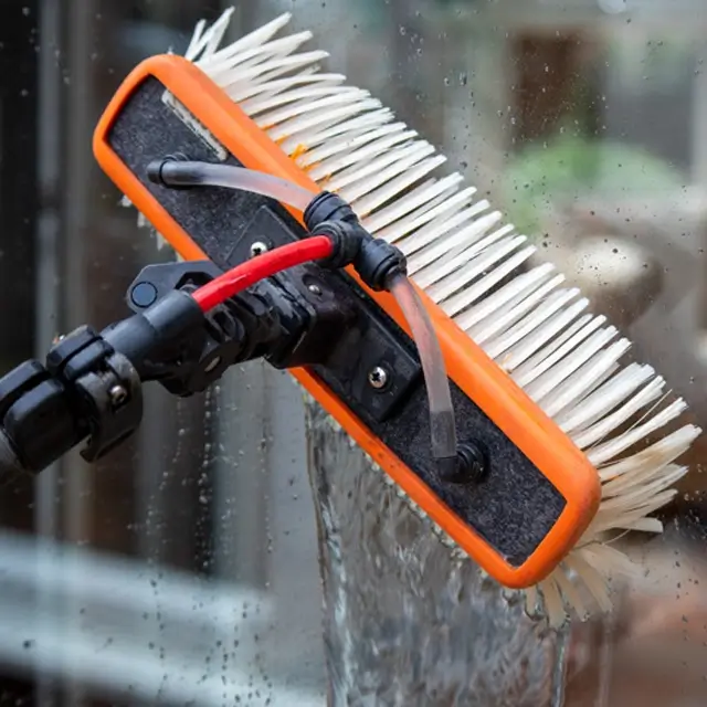 Professional window cleaning brush head using a pure water-fed system to scrub and rinse glass for a spot-free shine.